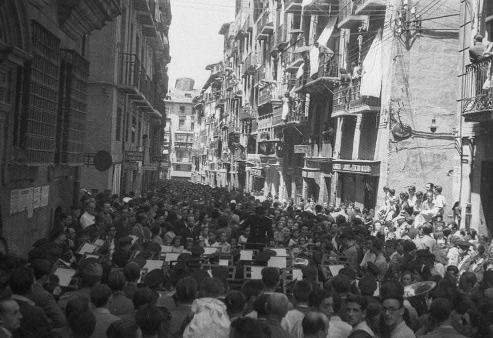 Imagen en blanco y negro de un multitudinario concierto de la Pamplonesa en la calle Estafeta. 